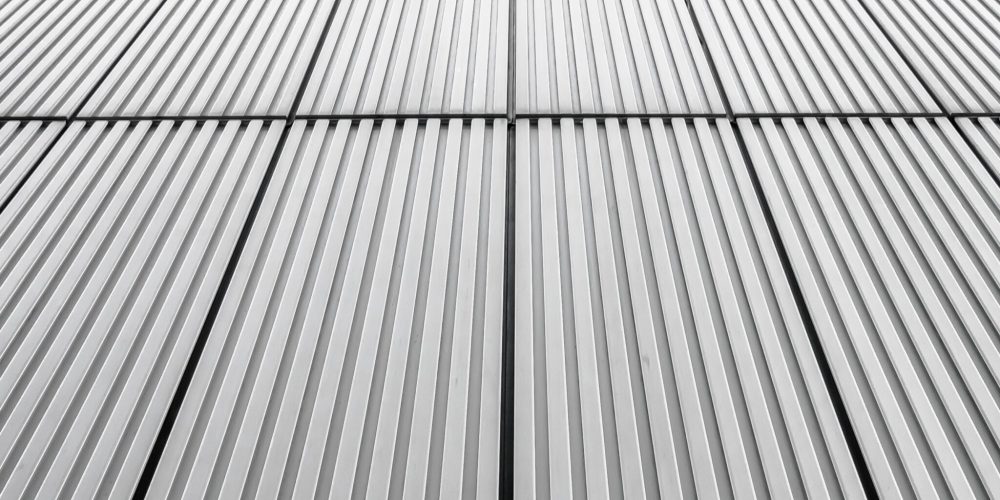 A vertical shot of a grey facade of a building - great for background or wallpaper